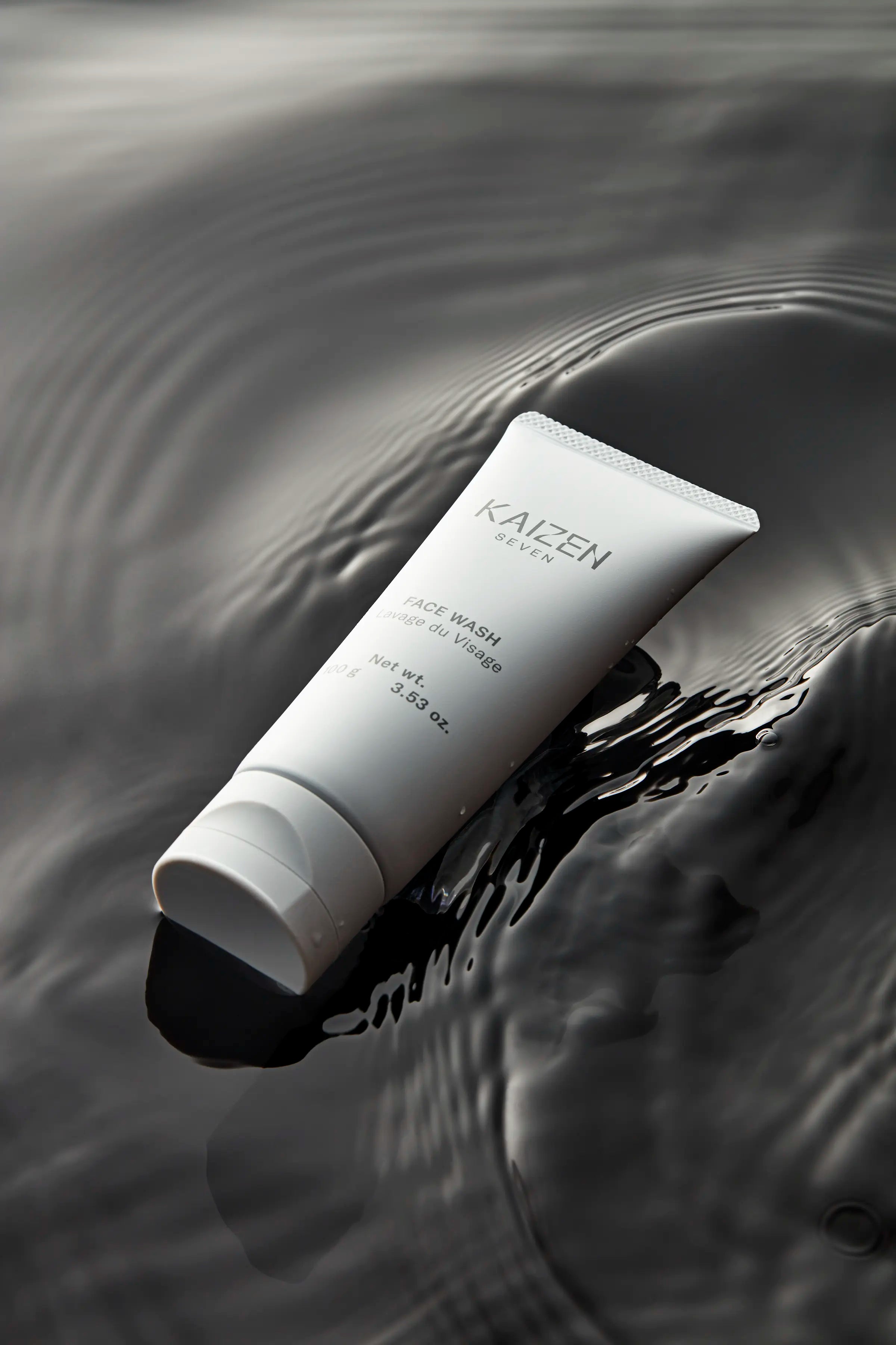 Photo of Kaizen Seven Face Wash floating in dark water with gentle waves surrounding 
