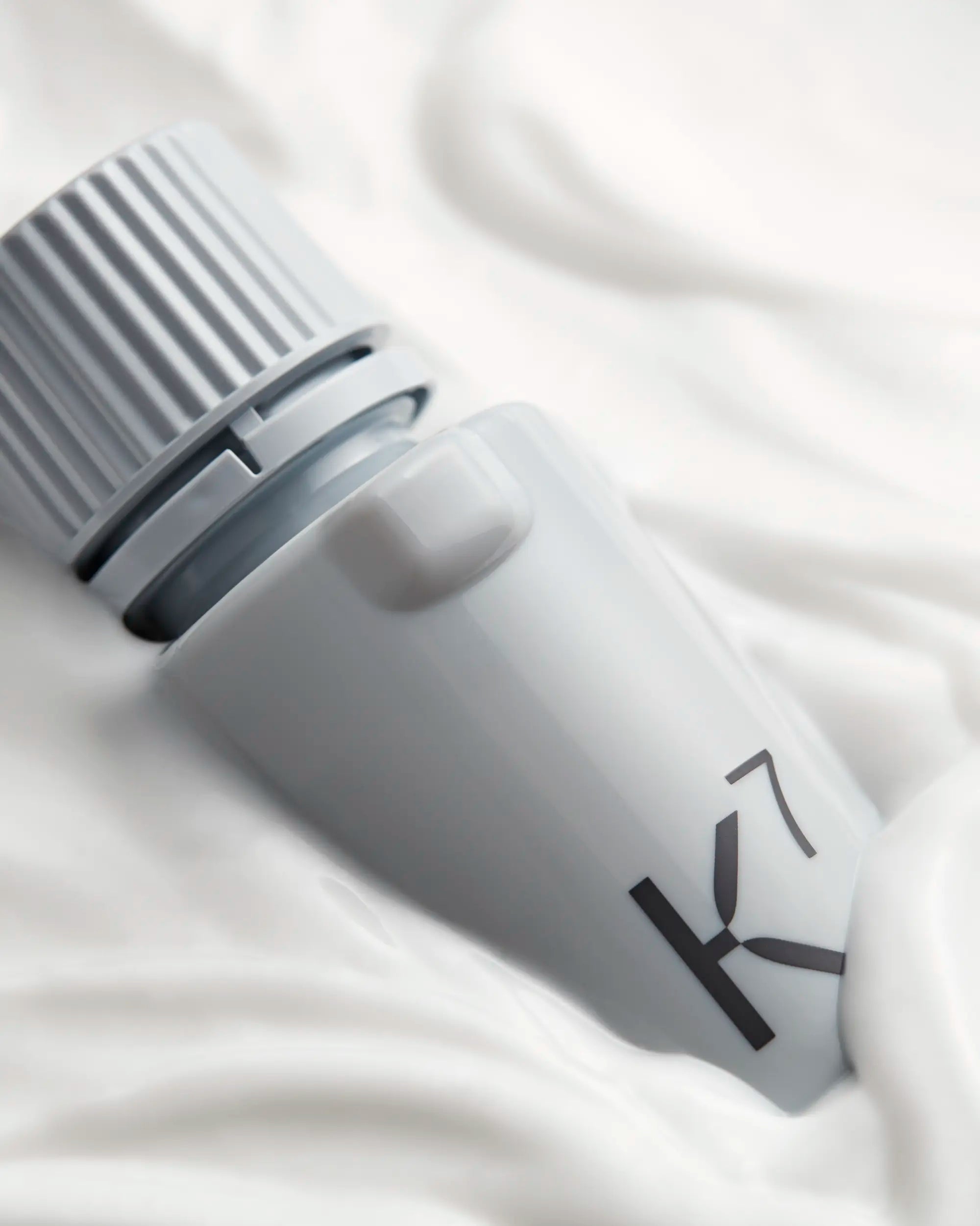 Close up of Kaizen Seven Light Moisturizer Refill rest in layer of moisturizer lotion