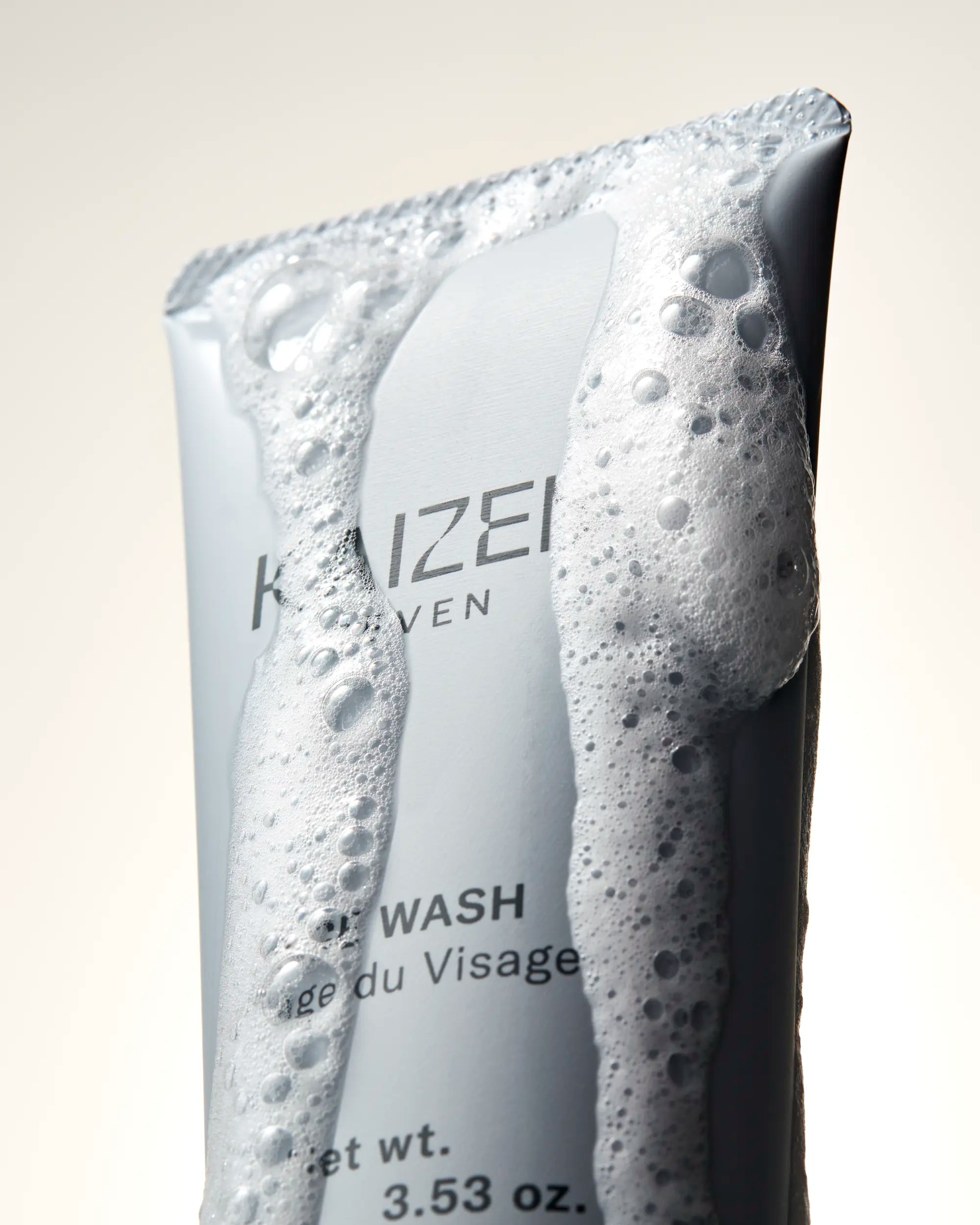 Close up of Kaizen Seven Face Wash with rich lather running down sides of packaging